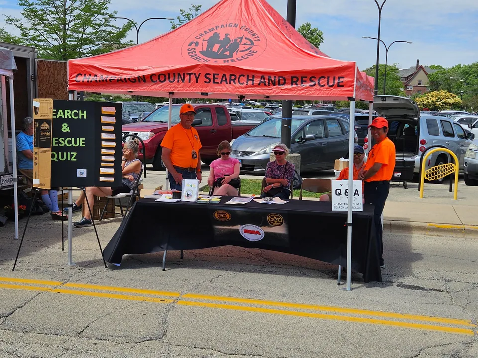 CCSAR volunteers staff an information table beneath a red tent at Market on the Square.